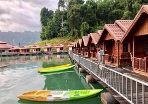 A row of wooden cabins with a waterway in front. - Saichol Floating Resort (Ban Ta Khun)