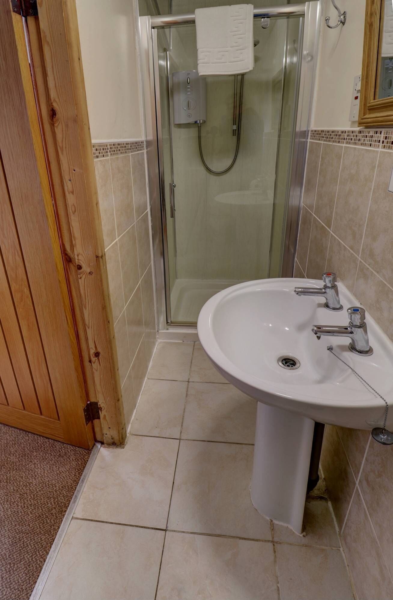 A bathroom with a shower, a sink, and a toilet.