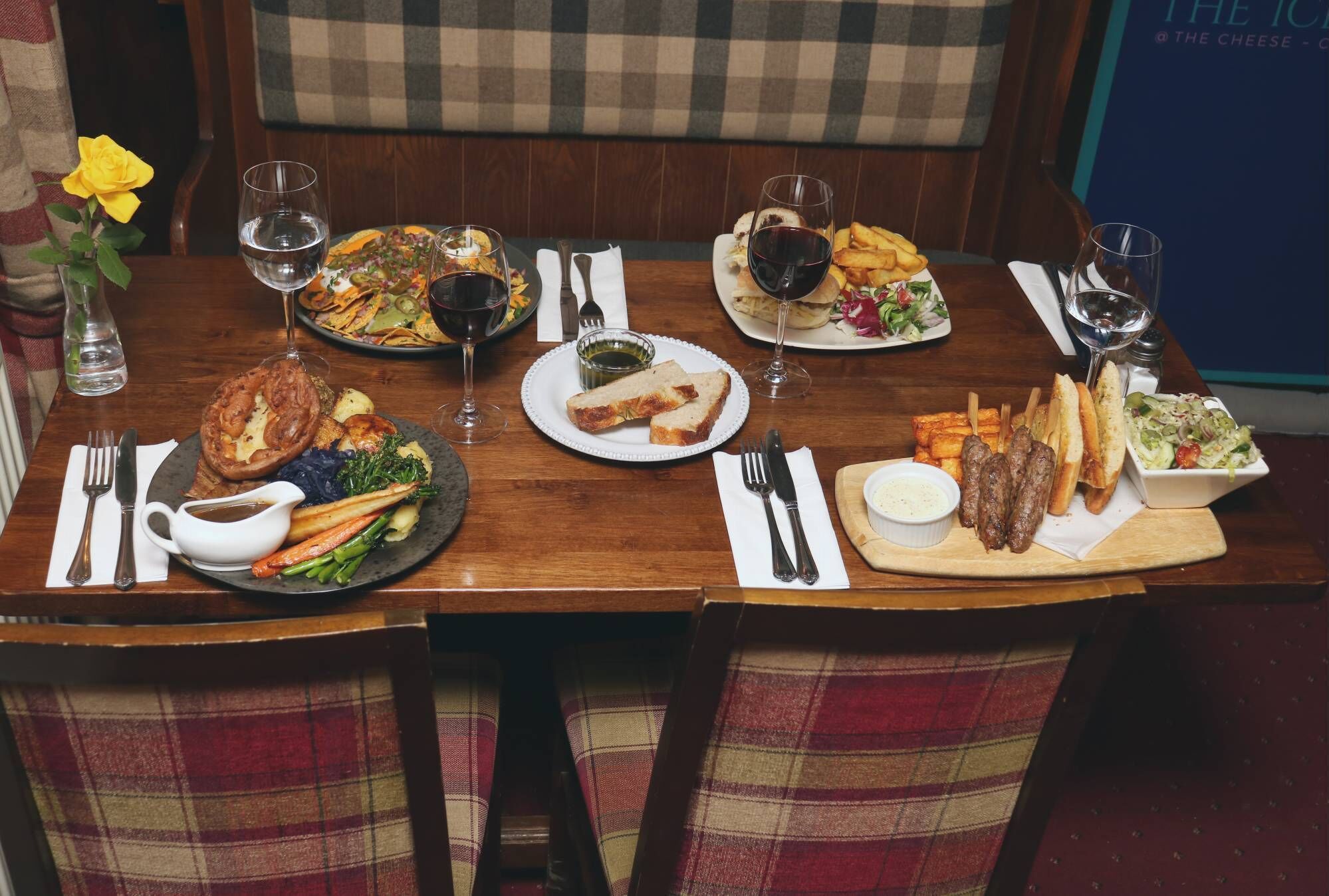 A dining table set with various dishes, wine glasses, and cutlery.