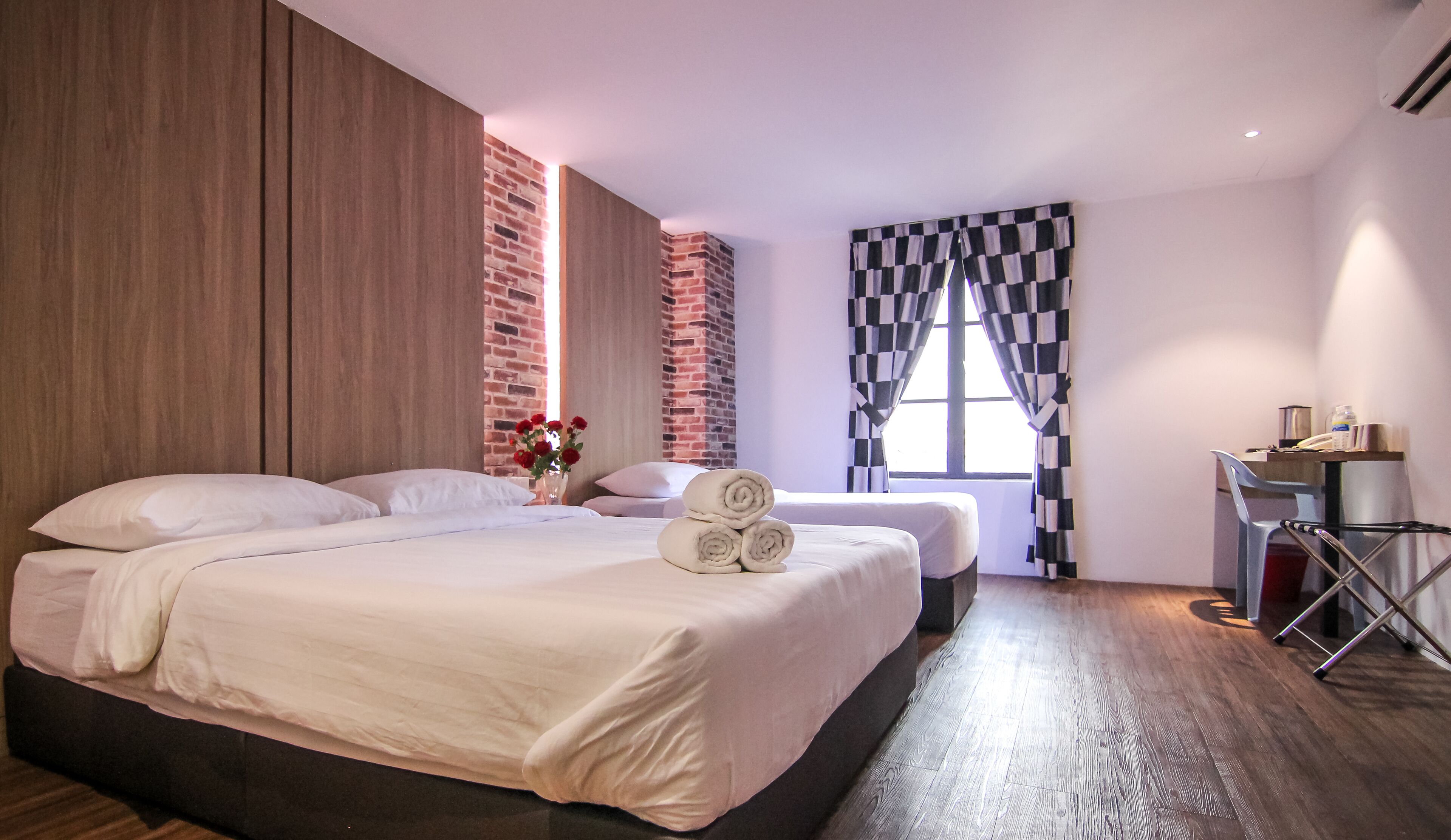 A modern hotel room with a large bed, a desk, and a view of the city.