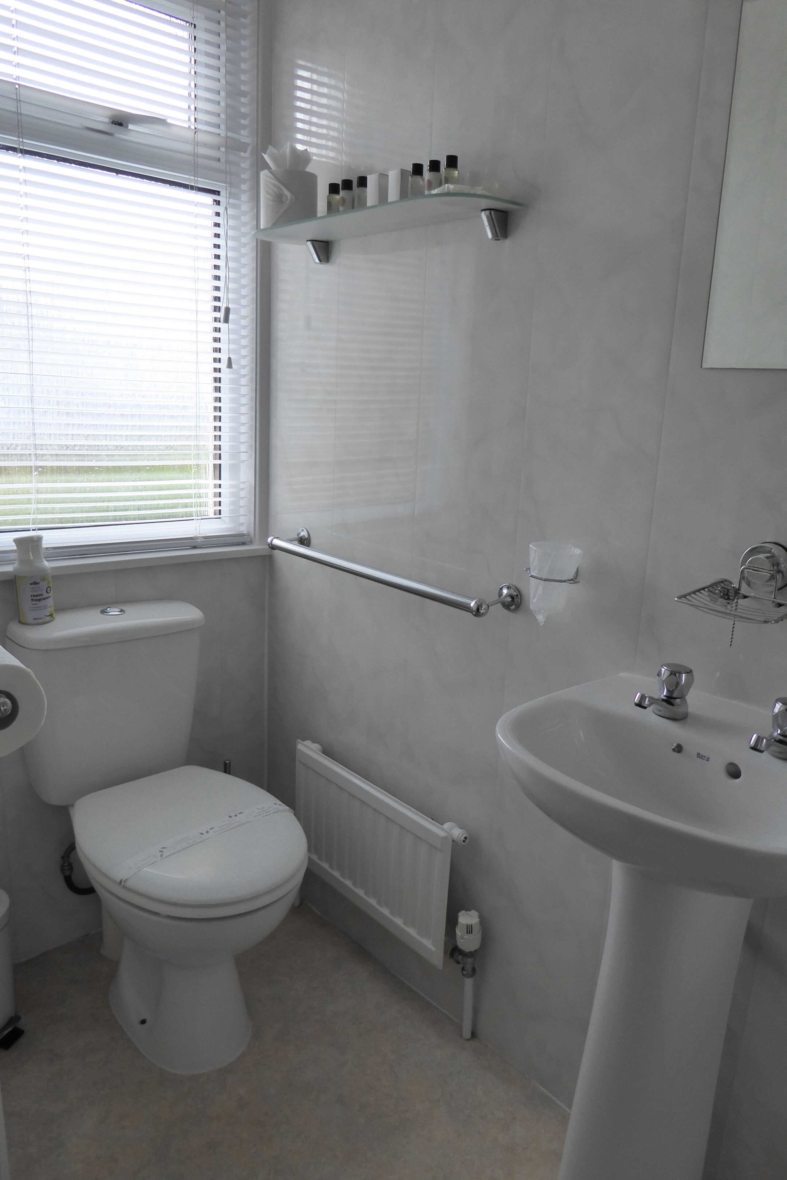 Ein modernes Badezimmer mit Toilette, Waschbecken und Fenster.
