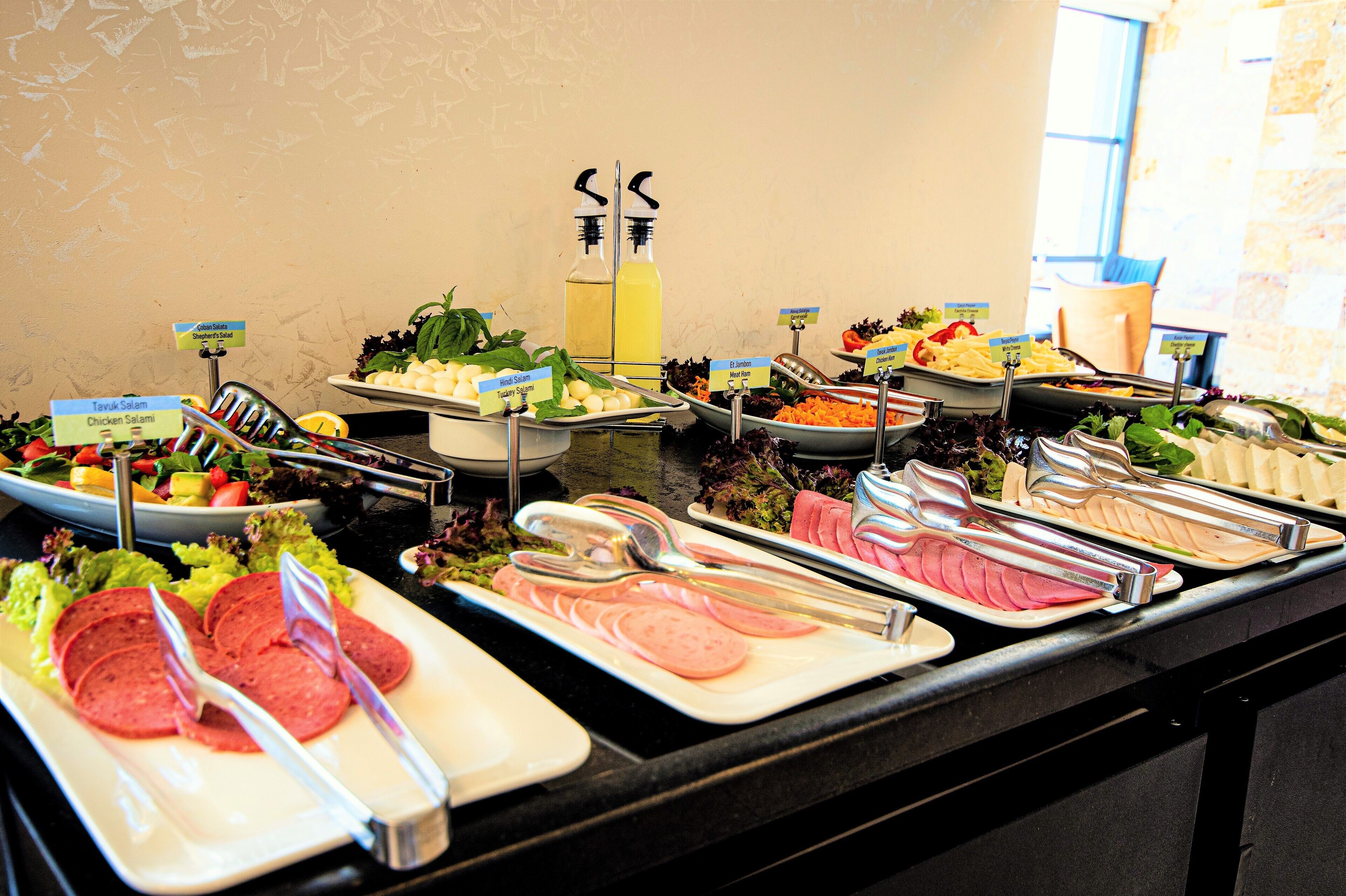 A buffet with various food options including salads, meats, and vegetables.