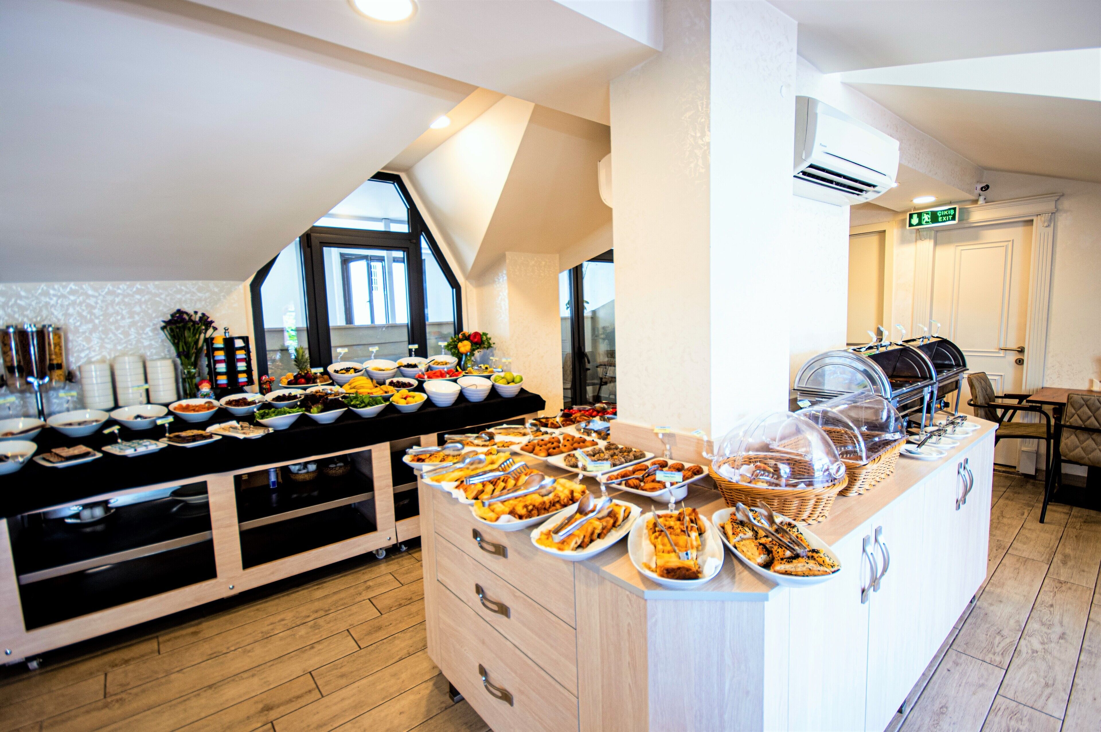 A buffet with various dishes and a seating area with a table and chairs.