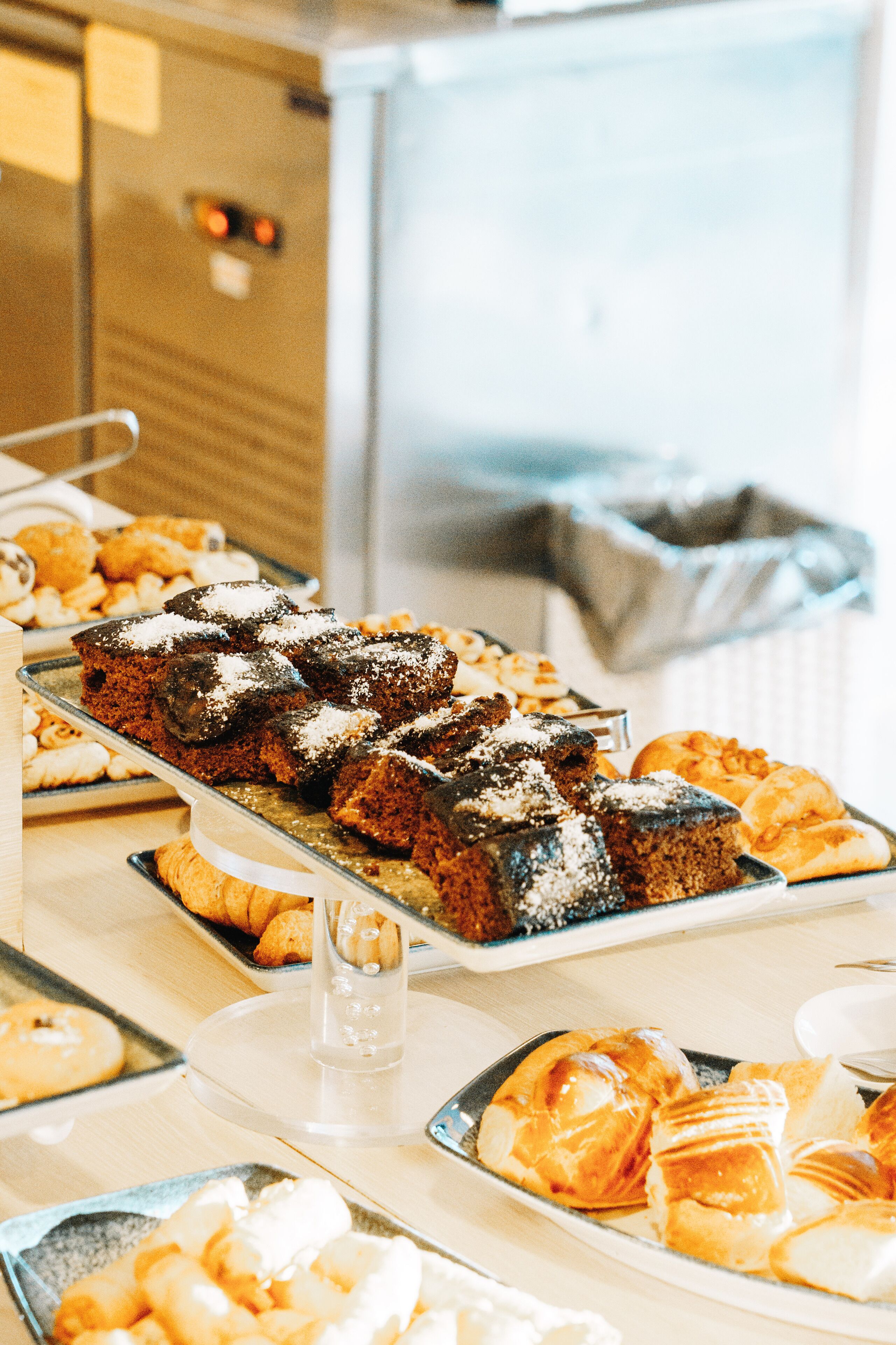 A buffet table with various baked goods including brownies and pastries.