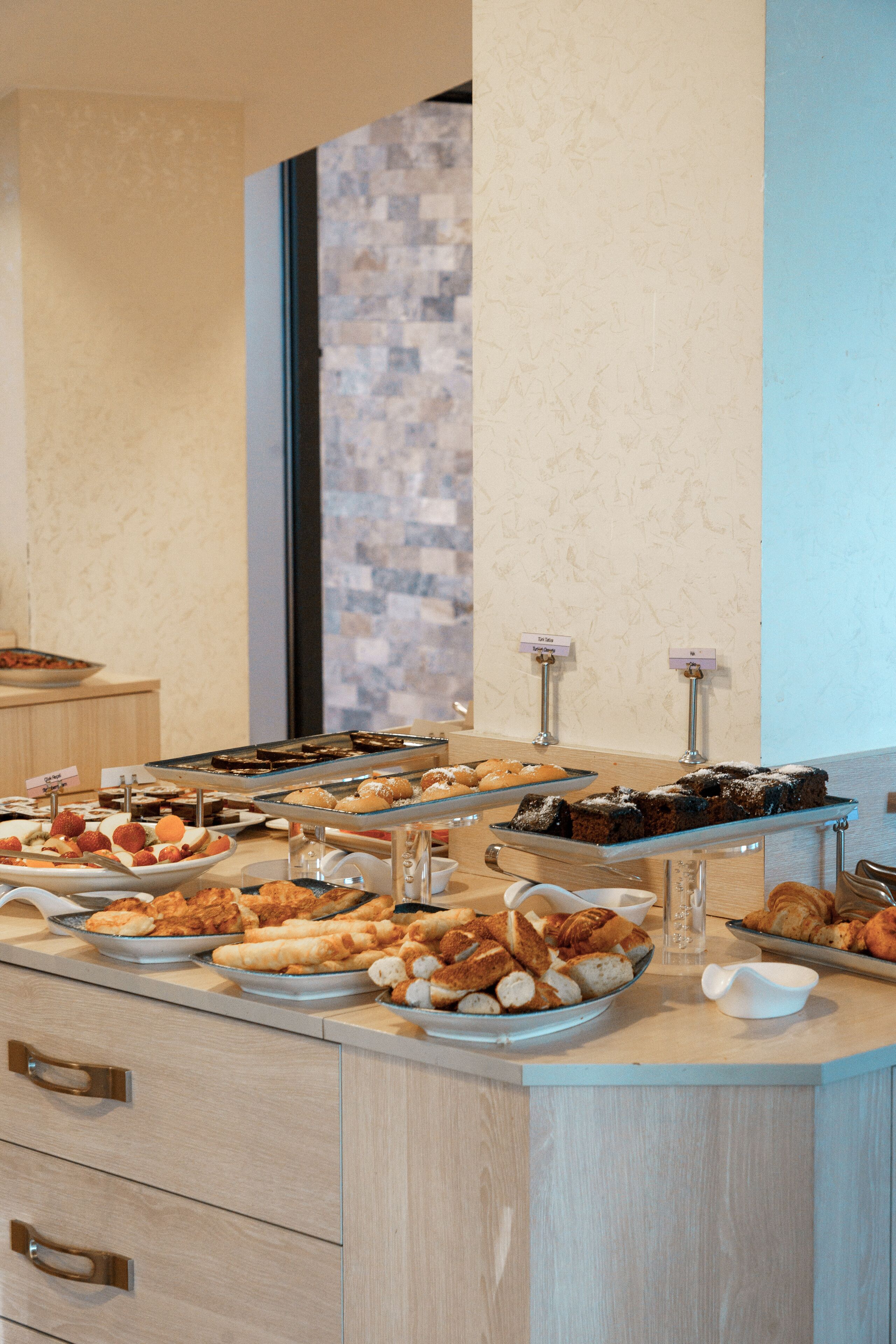 A buffet with various baked goods and pastries.