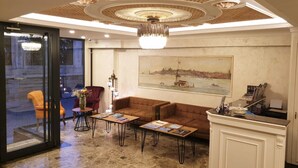 A lobby with a large painting, a chandelier, a reception desk, and seating areas. - Boss Hotel Sultanahmet (Istanbul)