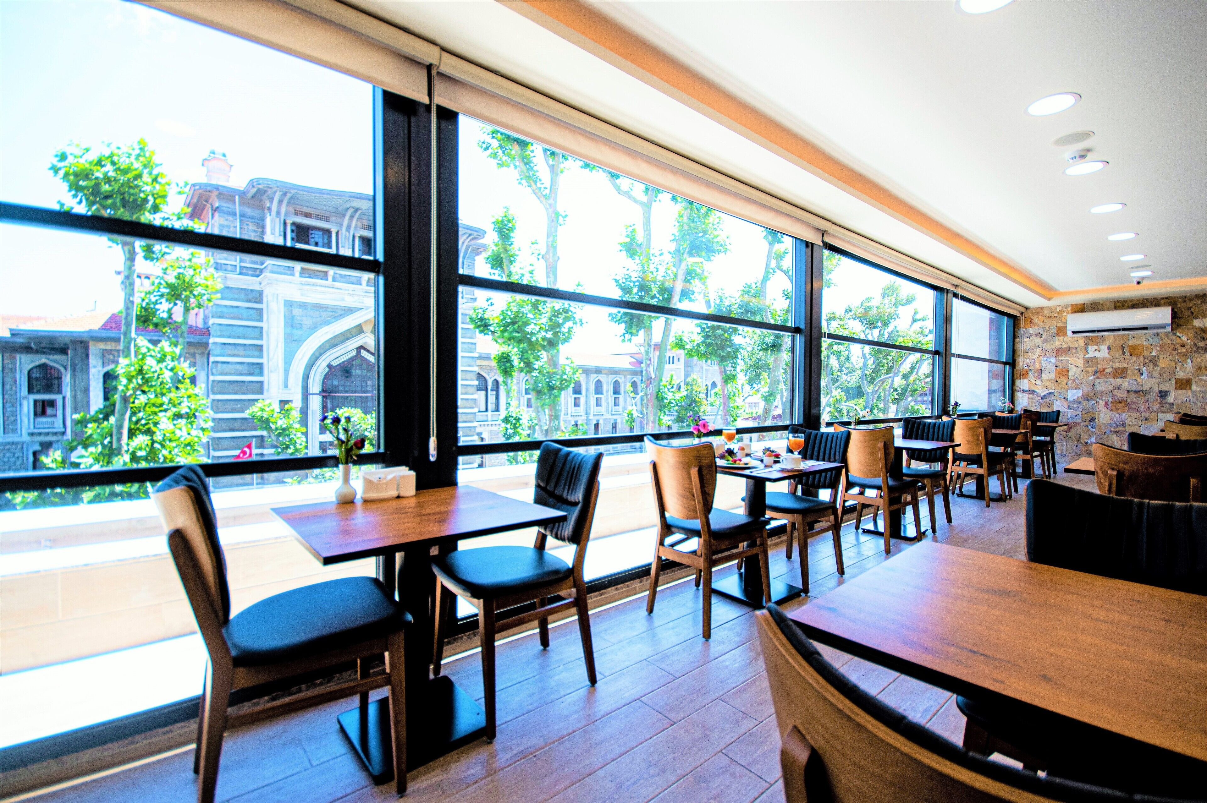 Un restaurant avec de grandes fenêtres, des tables et des chaises en bois.