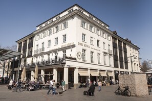 A historic building with a sign reading "Drei König." It features multiple balconies, large windows, and a central entrance with a covered area. - Kunst-Hotel Drei König am Marktplatz Stadt Lörrach (Loerrach)