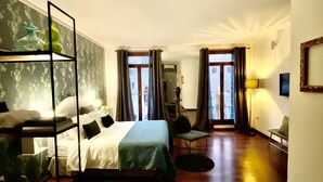 Habitación de hotel con literas, un escritorio, una silla y vista a la calle por la ventana.