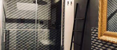 A bathroom with a shower, a sink, and a mirror.
