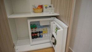 Een compacte koelkast met vriesvak, gevuld met drankjes en toevoegingen.
