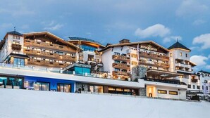 Un hotel de varios pisos con balcones, una pista de esquí frente al hotel y un cartel que dice "HOTEL CRYOSA".