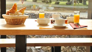 A breakfast table with croissants, bowls, cups, and orange juice glasses. - Auberge Des VoyaJoueurs (Monteneuf)