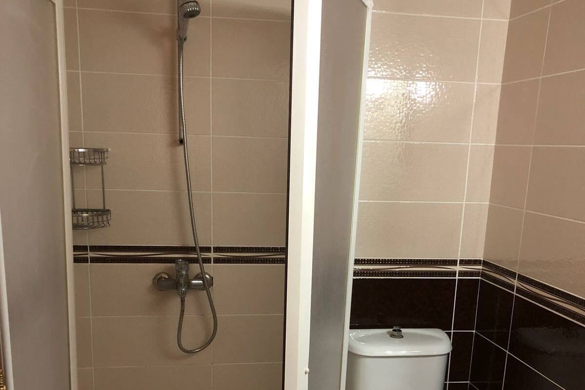 A bathroom with a shower, toilet, and sink.