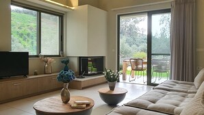 Amplia sala de estar con un sofá modular grande, un televisor de pantalla plana y un comedor con mesa y sillas.
