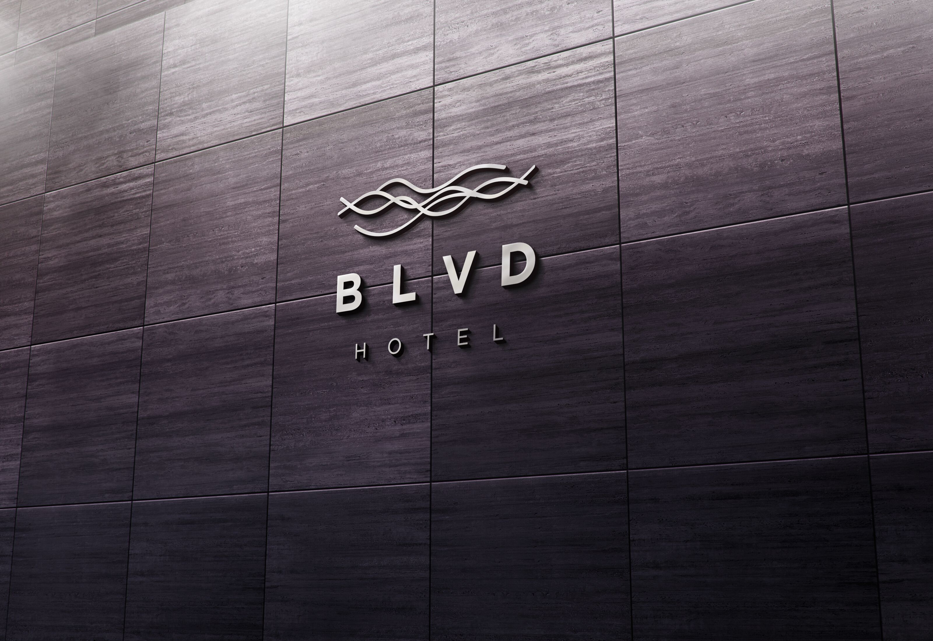 A hotel sign with the name 'BLVD HOTEL' on a dark tiled wall.