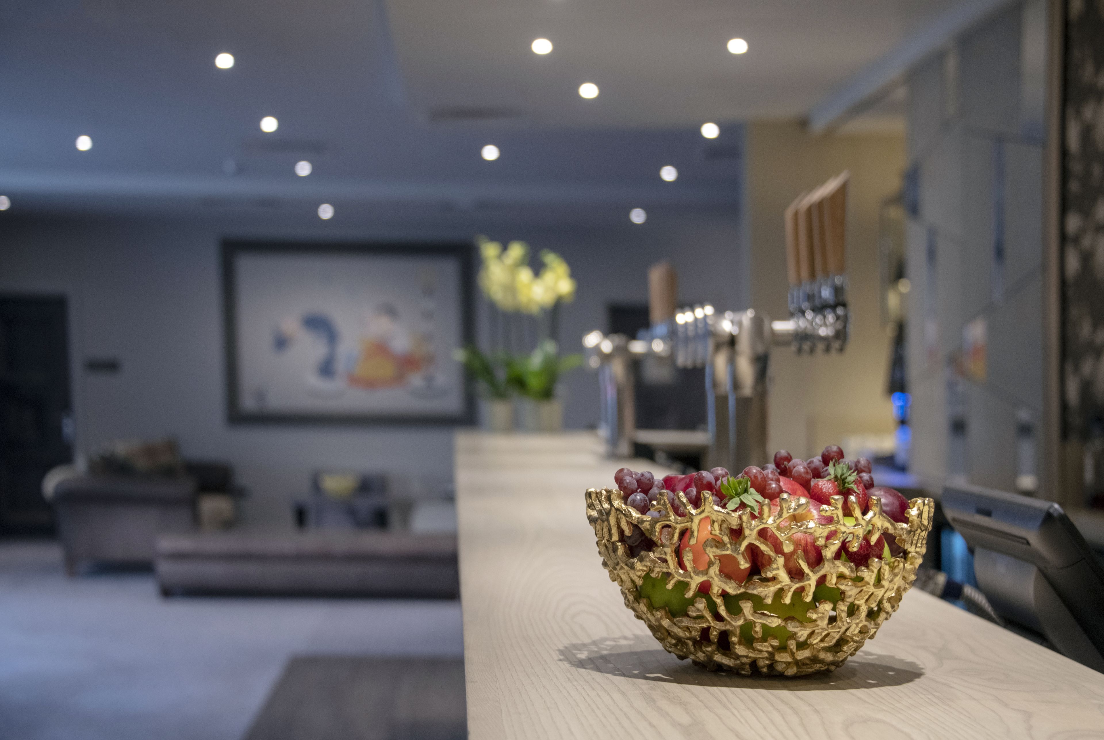 Un interior moderno con una mesa de madera que exhibe un cuenco decorativo con fruta.