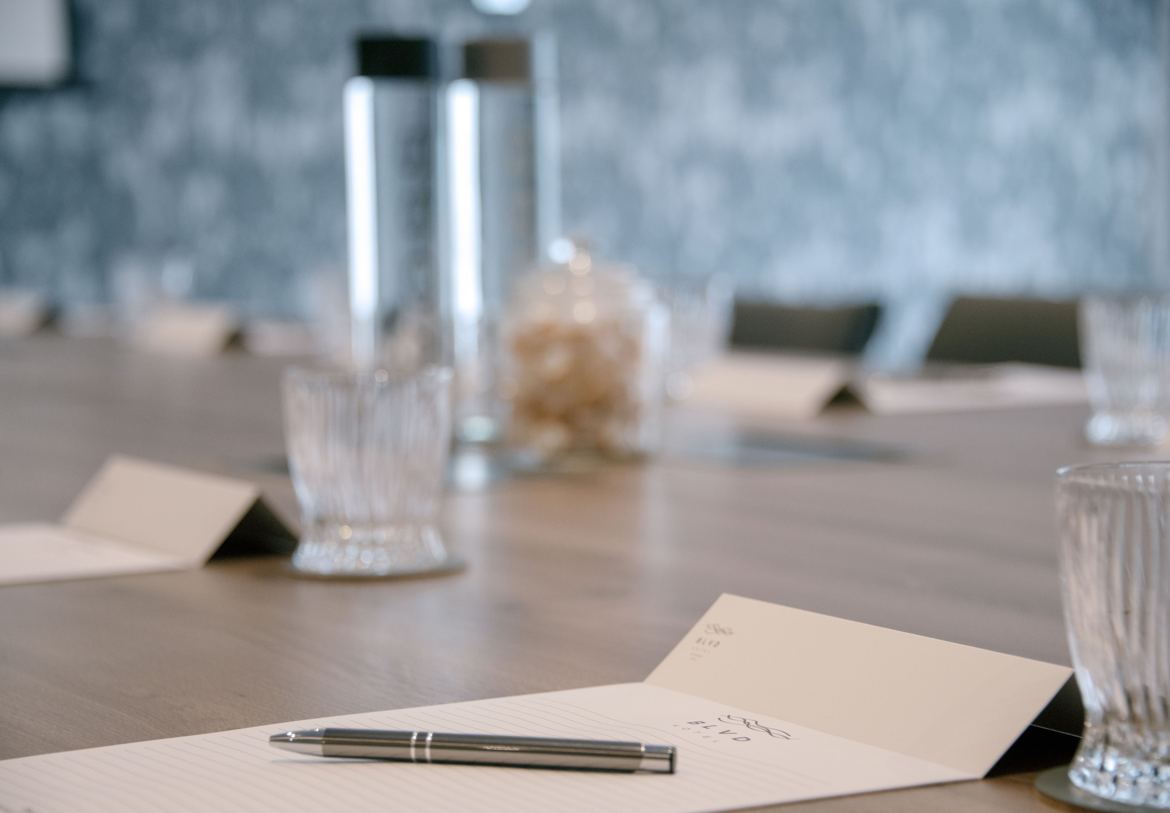 A conference table with a notepad, pen, and name cards.