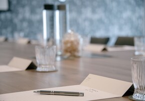 A conference table with a notepad, pen, and name cards.