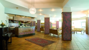 A spacious lobby with a bar area, seating, and a piano. - Magara Hotel (Spezzano della Sila)