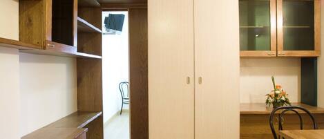A compact kitchen with wooden cabinets, a built-in bench, and a dining area with a table and chairs.