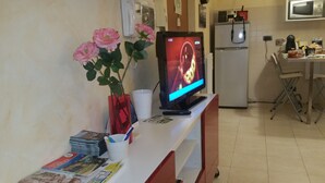 A kitchen area with a refrigerator, microwave, and a dining table with chairs. - B&B Le Terrazze Boutique Hotel 2 Torino (Cirie)