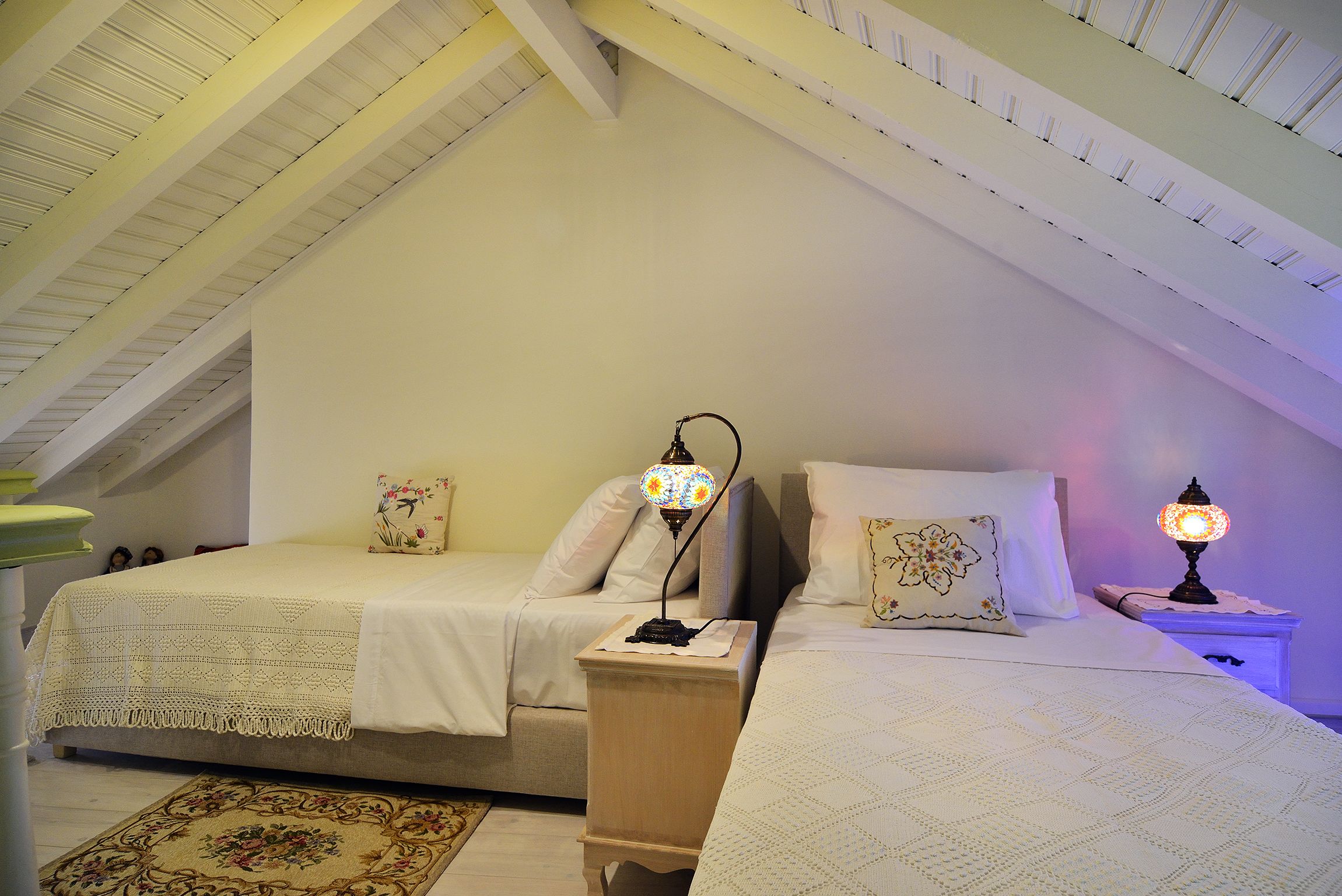 Ein Schlafzimmer mit zwei Betten, einem Nachttisch aus Holz und einer Nachttischlampe.