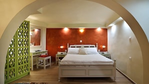 Une chambre à coucher avec un lit, des tables de chevet, un bureau et une chaise.
