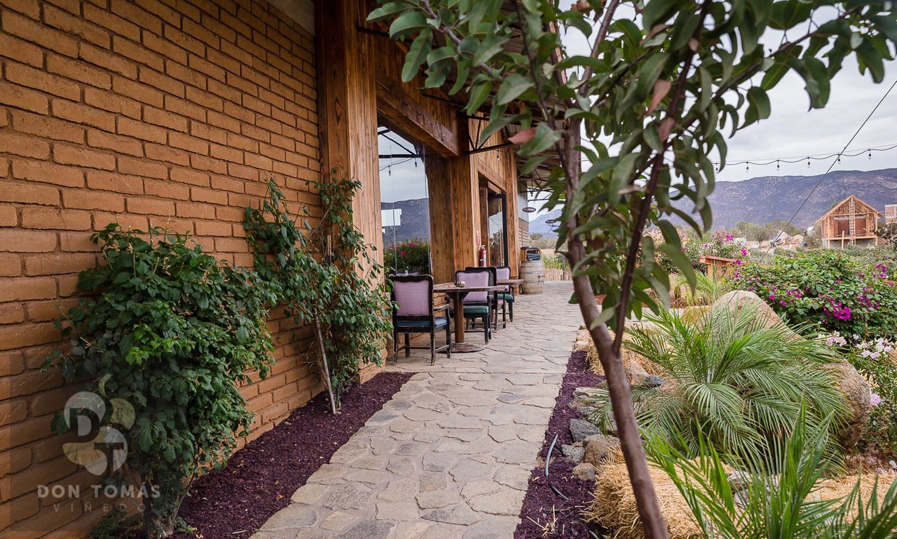 A brick building with a patio area featuring stone flooring and outdoor seating.