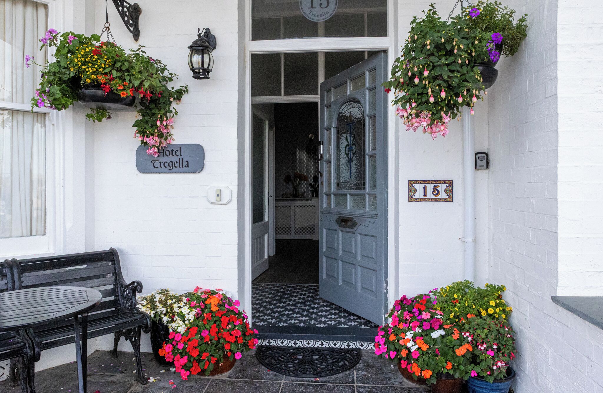 A hotel entrance with a white door, a sign reading 'Hotel Tregella,' and a number '15' on the wall.