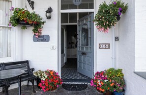 A hotel entrance with a white door, a sign reading 'Hotel Tregella,' and a number '15' on the wall. - Tregella Guest House (Newquay)