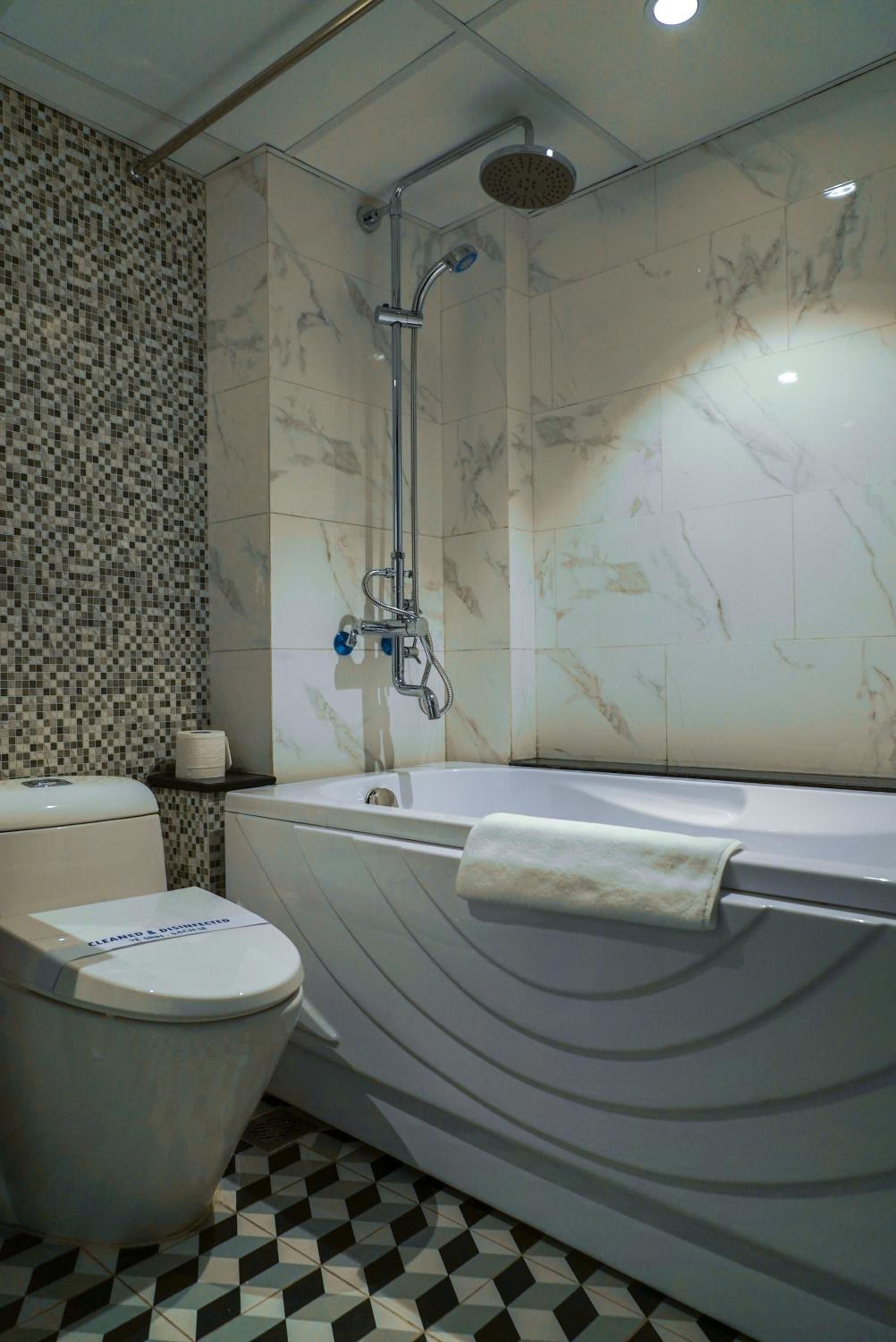 A bathroom with a toilet, a bathtub, and a shower.