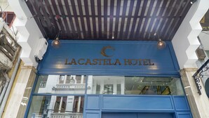 Fachada del Hotel Lacastela con una entrada azul y el número 29 Hang a la vista.