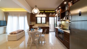 Een moderne keuken met een ingebouwde oven, een grote koelkast en een eethoek met een tafel en stoelen.
