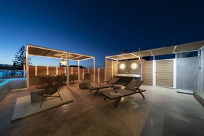 An outdoor patio area with seating, a barbecue grill, and a covered seating area.