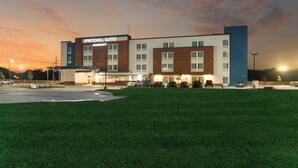 Ein Hotel mit modernem Design, mit flachem Dach, Parkplatz und gepflegtem Rasen.