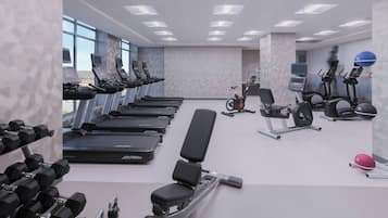 Een sportschool met loopbanden, elliptische trainers, een bankdrukapparaat en gewichten.
