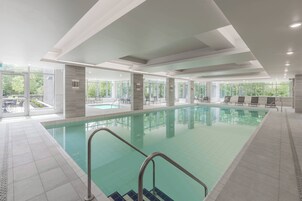 Una piscina techada, sillones reclinables de piscina