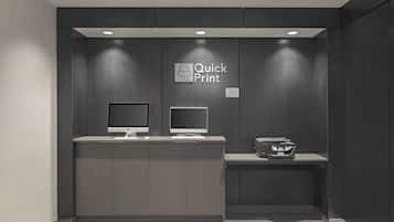 A reception desk with a monitor, a printer, and a sign that reads "Quick Print".