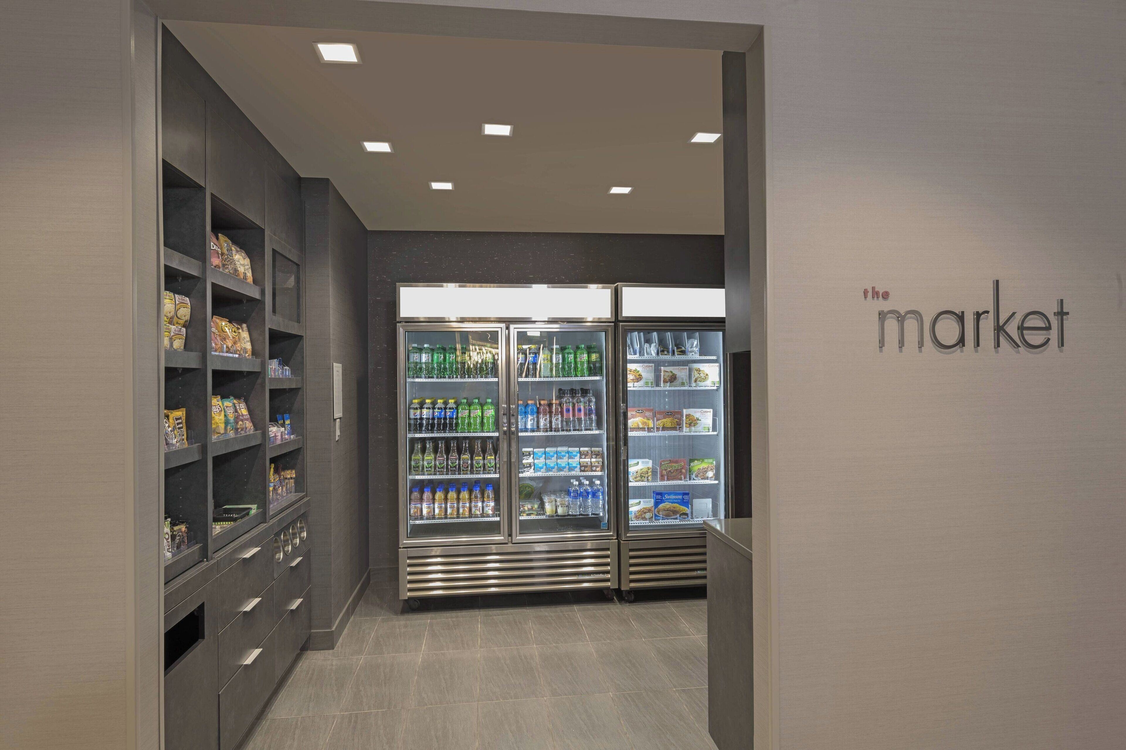 A modern grocery store interior with refrigerated sections and shelves stocked with various products.