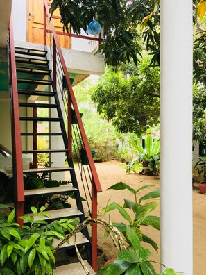 Un escalier avec une rampe rouge menant à une porte en bois.