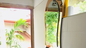 A bathroom with a sink, mirror, and potted plants.