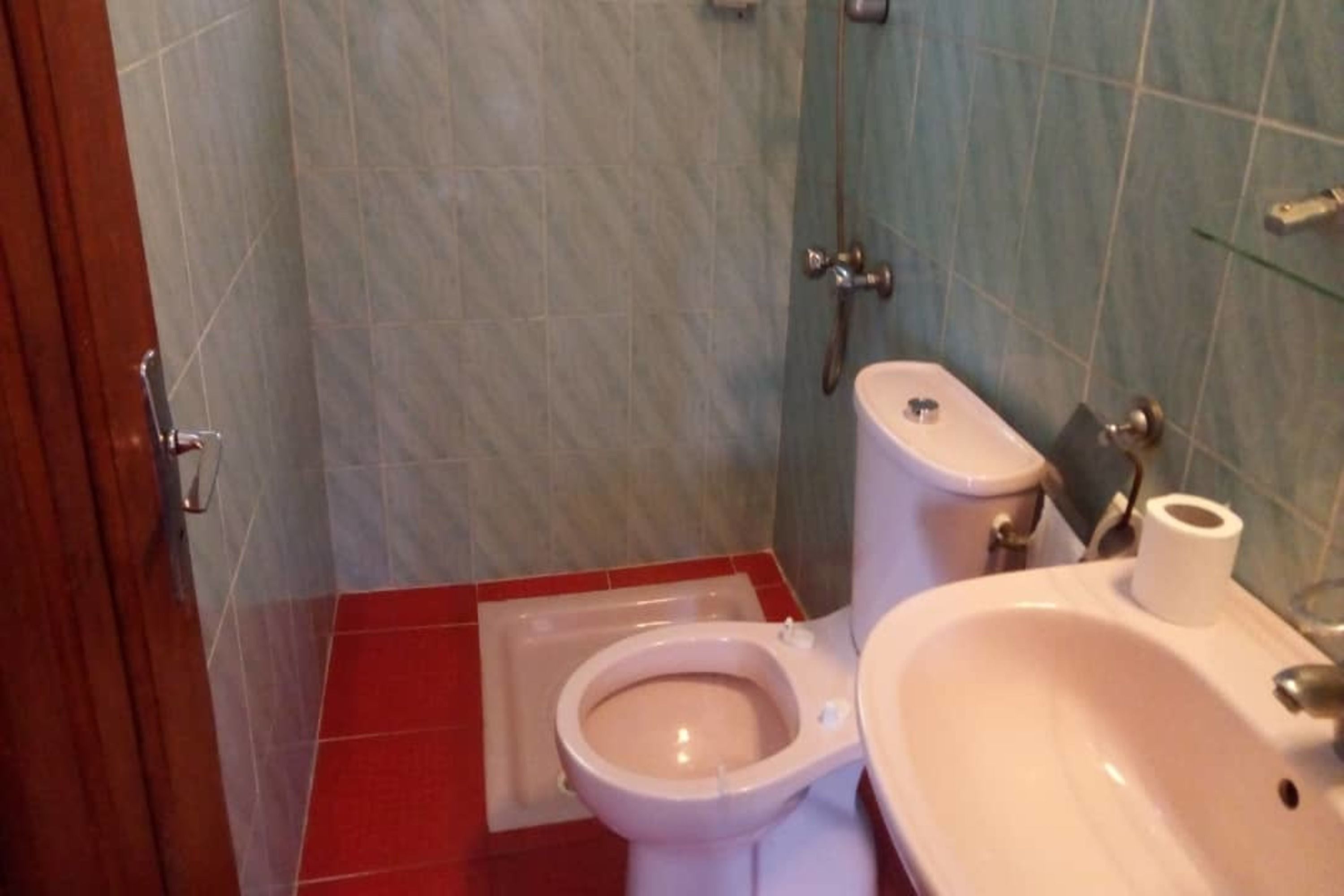 A bathroom with a toilet, bidet, and sink.
