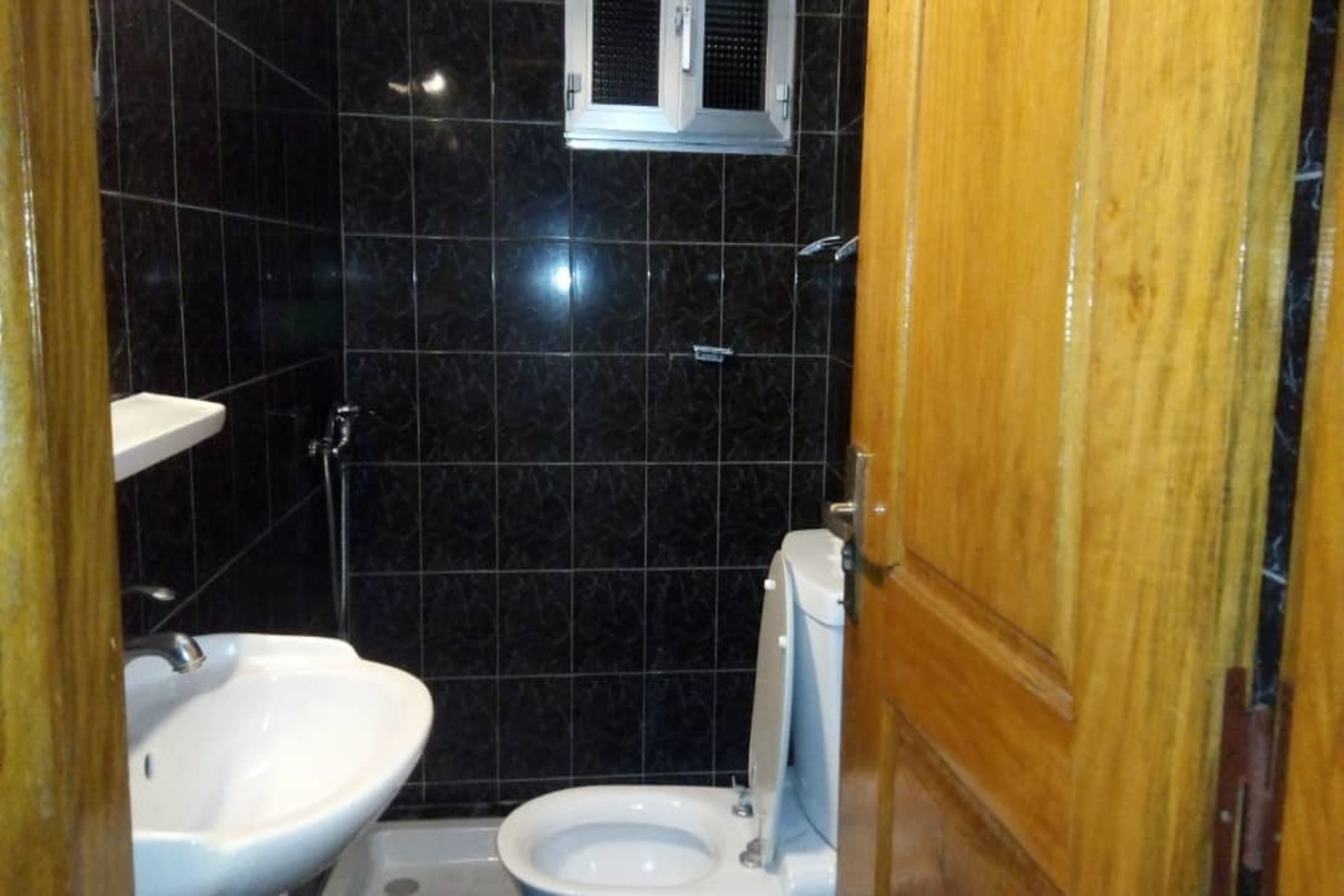 A bathroom with a white sink, a toilet, and a shower area.
