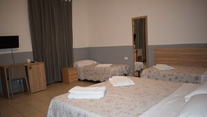 A hotel room with two beds, a desk, a chair, and a television. - Golden Dream Guest House (Florence)