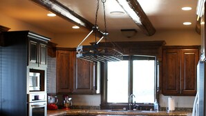A kitchen with dark wooden cabinets, a granite countertop, stainless steel appliances, and a large island with a sink.