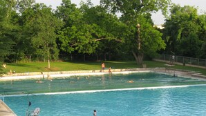 A swimming pool with multiple lanes, surrounded by a grassy area and trees. - Uptown Downtown Office, Fenced Yard, Pools, Walk to Parks, Near Major Employers (Austin)