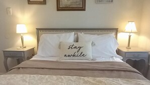 A neatly made bed with a decorative pillow, two bedside lamps, and framed artwork on the wall. - Uptown Downtown Office, Fenced Yard, Pools, Walk to Parks, Near Major Employers (Austin)