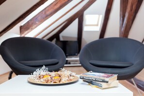 A dining table with a plate of food and books, two black chairs, and a wooden ceiling structure. - Hedera Estate, Hedera A5 - Breakfast included (Dubrovnik)