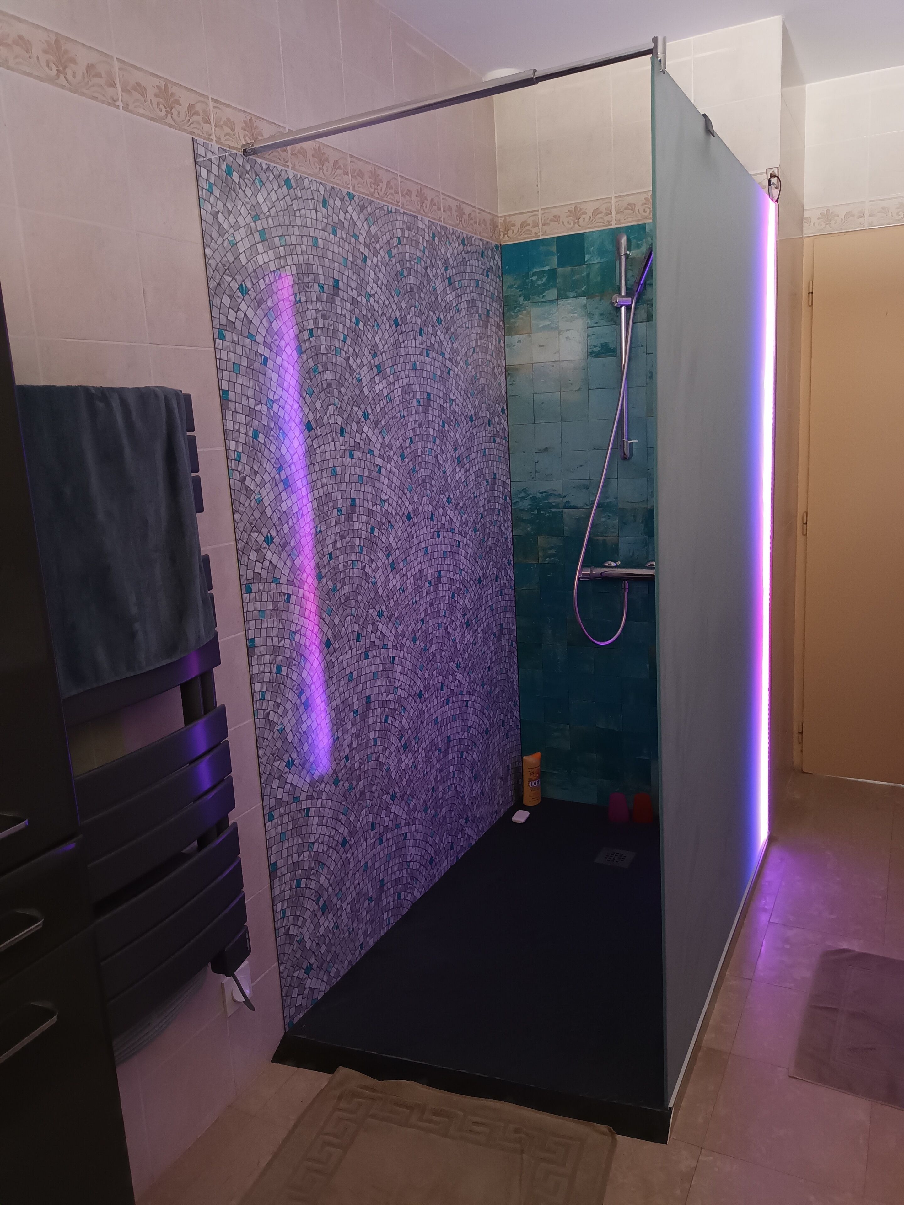 A modern bathroom with a shower area, a towel rack, and a toilet.